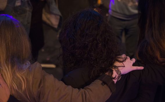 two women hand together on each other's shoulders to contemplate