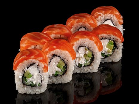 Several sushi rolls Philadelphia. Black background with reflection.