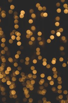 Bokeh light with glittering golden flares on a dark background with a matte effect