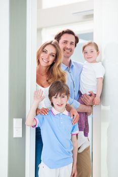 Portrait of happy smiling family with little children in doorway