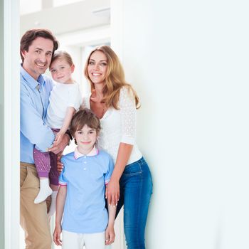 Portrait of happy smiling family with little children in doorway