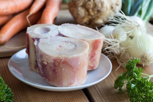 Ingredients for making a beef bone broth - marrow bones, carrots, onions, parsley, and celery root