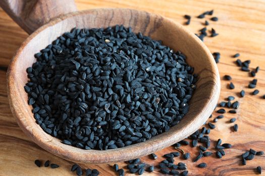 Black cumin seeds on a wooden spoon