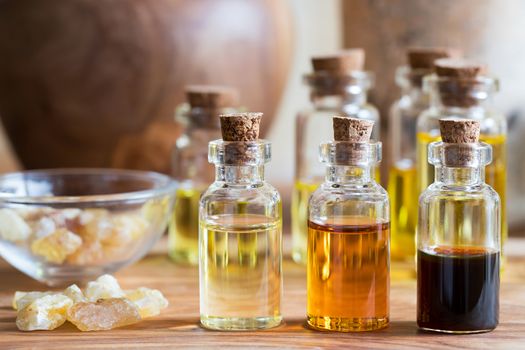 Bottles of essential oil with rankincense resin on a wooden table