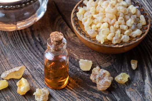 A bottle of essential oil with frankincense resin crystals