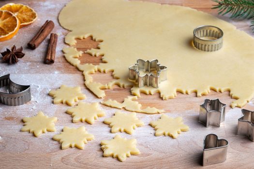 Cutting out star shapes from rolled out dough to prepare traditional Linzer Christmas cookies