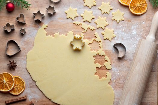 Cutting out star shapes from rolled out dough to prepare traditional Linzer Christmas cookies