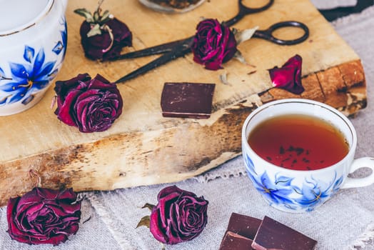 Cup of Tea.with Dry Roses Buds and Chocolate.