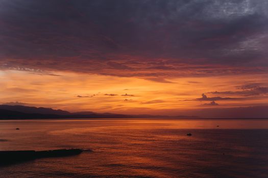 landscape red sunrise over the sea ocean on the horizon of the mountain