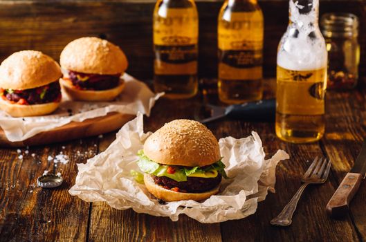 Three Burgers with Bottles of Lager Beer.
