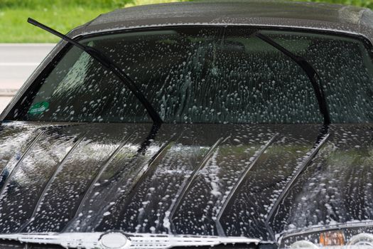 Manual car wash with pressurized water in the car wash outside.