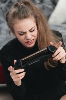 young girl woman gamer playing on the phone with a gamepad close-up