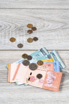 some Malaysian Ringgit banknotes and coins on a wooden table