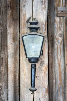 Vintage lamp with dusty glass hanging on a wooden wall