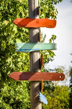 Wooden sign shaped like arrows showing directions in various colors