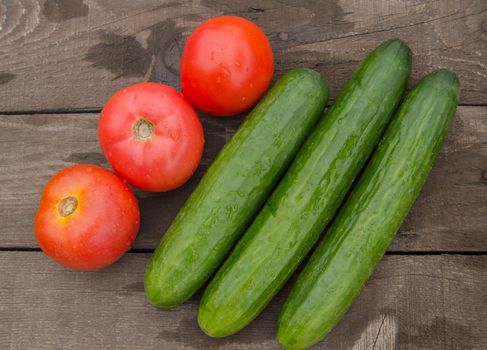 The concept of healthy eating with organic cucumber and cherry tomatoes on wooden table