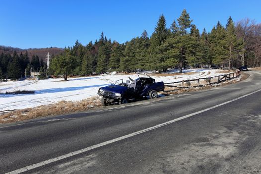 Front of blue car damaged by crash accident on side of the road