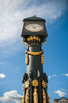An old golden clock Tower in front of a church