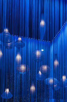 Blue light installation with lamps and fabric stripes