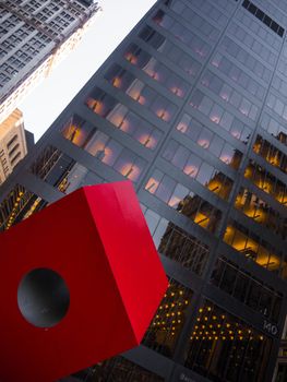 Red cube die in front of black facade Manhattan Downtown Skyscraper
