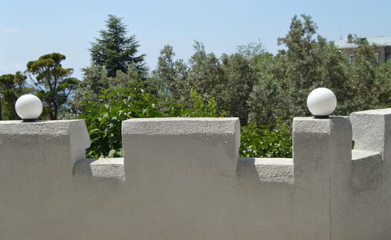 Beautiful view of the white stone fence terraces decorated with lanterns on a Sunny summer day.