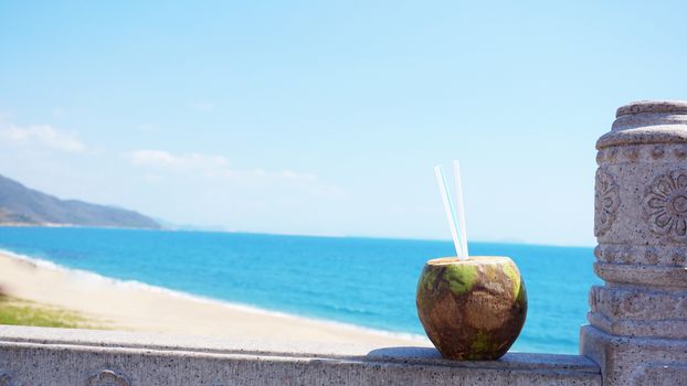 Coconut water drink on a tropical beach. Sea Beach in the background