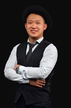 Asian young man in a hat smiles and looks at the camera