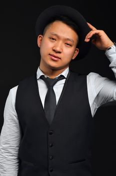 Photo of an Asian man with a tie and a shirt, he raises his hat by congratulating