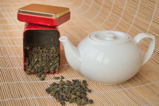 Teapot and a tin of traditional Asian green tea loose.