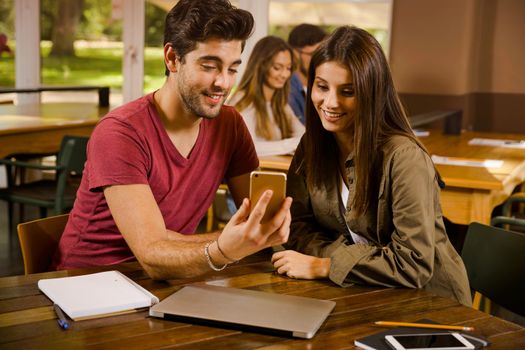 Friends studying together and watching something on the phone