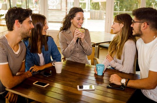 A group of friends talking and drinking coffee at the cafe