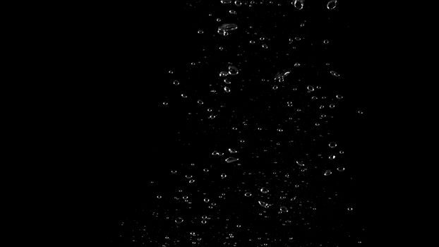 Extream close-up images of water bubbles or soda or liquid texture that splashing and floating up to surface like a explosion in black color background for refreshing carbonate drink concept.