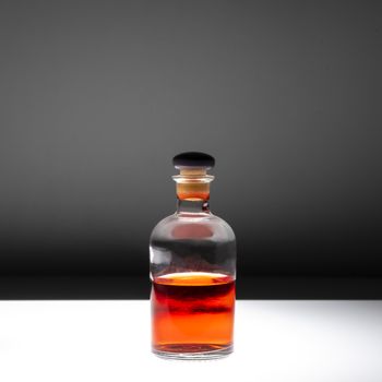 Small glass bottle containing red liquid