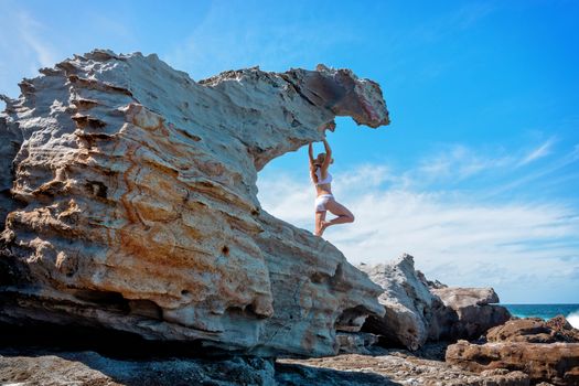 Woman stands in one of the many weathered sandstone rocks taking on various unique shapes on remote area of Auistralia