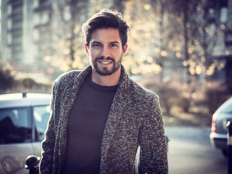 One handsome young man in urban setting in European city, standing