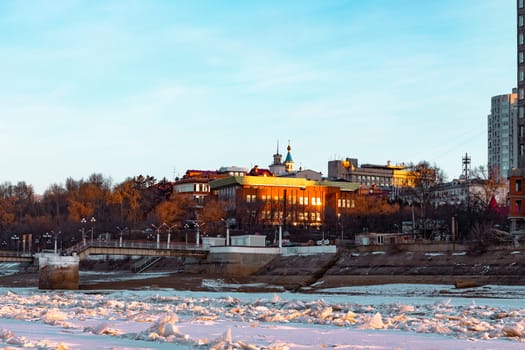 View of the city of Khabarovsk from the middle of the frozen Amur river. Factories on the horizon.