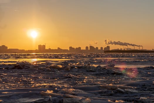 View of the city of Khabarovsk from the middle of the frozen Amur river. Factories on the horizon.