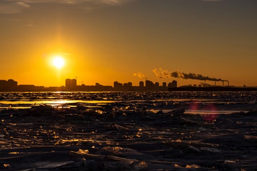 View of the city of Khabarovsk from the middle of the frozen Amur river. Factories on the horizon.