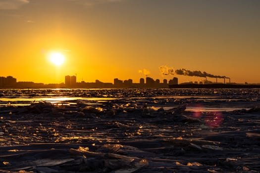 View of the city of Khabarovsk from the middle of the frozen Amur river. Factories on the horizon.