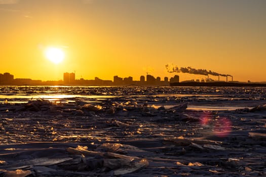 View of the city of Khabarovsk from the middle of the frozen Amur river. Factories on the horizon.