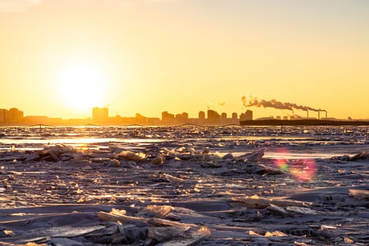 View of the city of Khabarovsk from the middle of the frozen Amur river. Factories on the horizon.