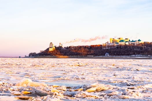 View of the city of Khabarovsk from the middle of the frozen Amur river. Factories on the horizon.