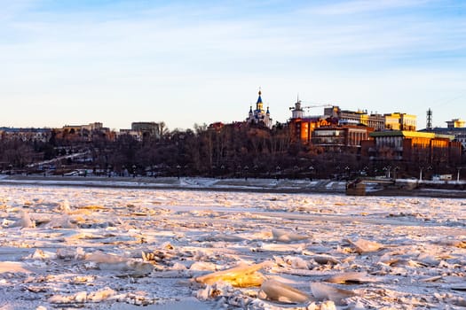 View of the city of Khabarovsk from the middle of the frozen Amur river. Factories on the horizon.