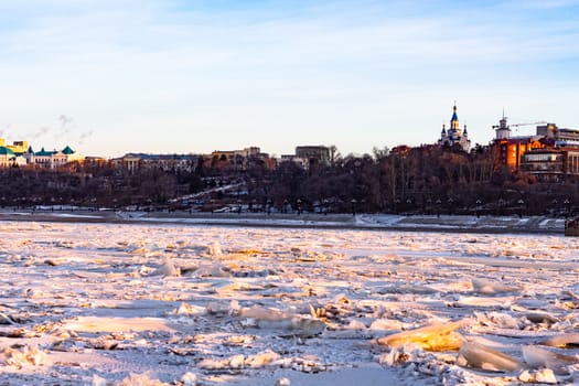 View of the city of Khabarovsk from the middle of the frozen Amur river. Factories on the horizon.