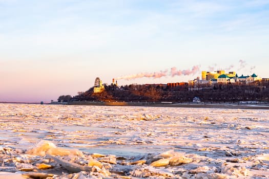 View of the city of Khabarovsk from the middle of the frozen Amur river. Factories on the horizon.