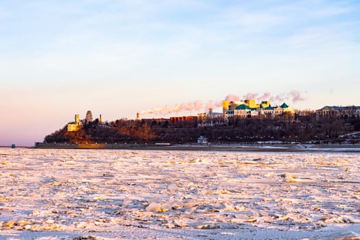 View of the city of Khabarovsk from the middle of the frozen Amur river. Factories on the horizon.