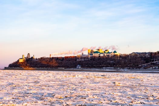 View of the city of Khabarovsk from the middle of the frozen Amur river. Factories on the horizon.