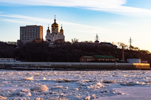 View of the city of Khabarovsk from the middle of the frozen Amur river. Factories on the horizon.