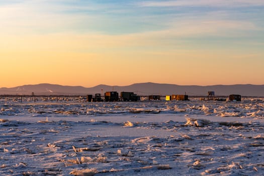 View of the city of Khabarovsk from the middle of the frozen Amur river. Factories on the horizon.