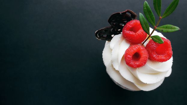 Delicious raspberry cupcakes on dark background - Handmade Sweet dessert, cupcake with butter cream and raspberry